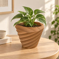 Maceta Twist 3D color terracota con planta en ambiente cálido de hogar