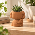 Matera Muñequita con Zorrito 3D en color terracota ambientada con una planta pequeña